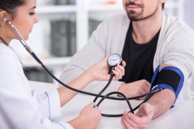 médecin mesure la tension artérielle dans l'hypertension